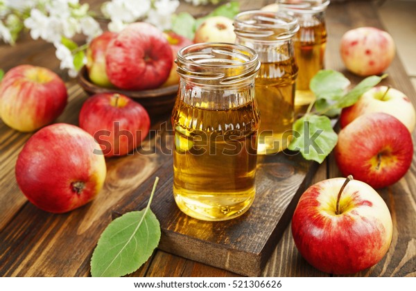 Fresh apple\
juice in the bottle on the wooden\
table