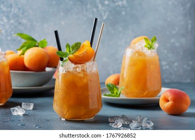 Fresh apricot cocktail with ice and mint on the blue background. Selective focus image. Bar concept and summer drinks concept