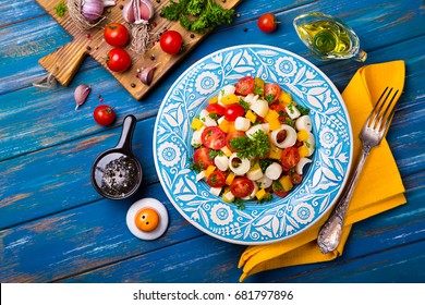 Fresh argentine salad of heart of palm (palmito), cherry tomatoes, yellow bell pepper, garlic and parsley on wood blue background