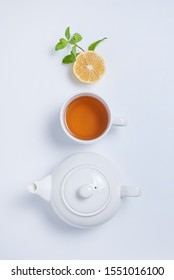 Fresh Aroma Cup Of Black Tea And Tea Pot With Lemon, Mint And Golden Spoon On White  Background. Top View And Copy Space. Vertical Orientation.