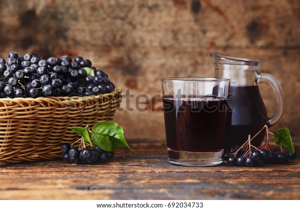 Fresh\
aronia berries and aronia berry juice in\
glasses