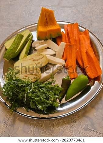 Fresh assorted vegetables including carrots, zucchini, pumpkin, cabbage, turnip and herbs prepared on a tray for traditional Moroccan couscous cooking.