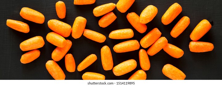 Fresh Baby Carrots On A Black Background, Top View. Flat Lay, Overhead, From Above.