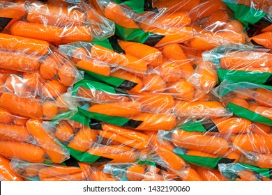 Fresh baby carrots in plastic bags in the grocery store