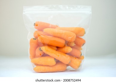 fresh baby carrots in plastic bags white background