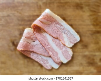 Fresh Bacon Slab On Wood Background.