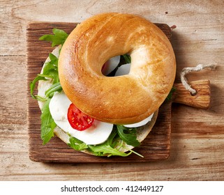 Fresh Bagel Sandwich On Wooden Table, Top View