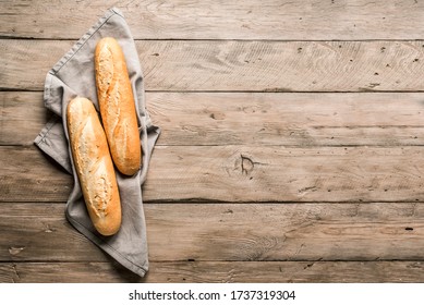 Fresh Baguette Bread on wooden background. Homemade french two Baguette loafs, top view, copy space. - Shutterstock ID 1737319304