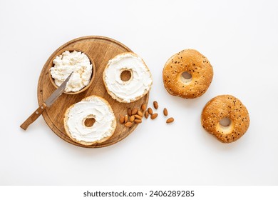 Fresh baked bagels with cream on board, top view. Healthy breakfast background.