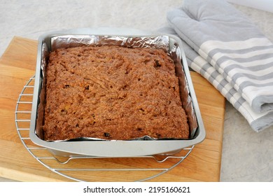 Fresh Baked Banana Bread With Raisins And Cinnamon Sugar Topping. In Square Cake Pan On Cooling Rack With Oven Mitts. Horizontal Format.