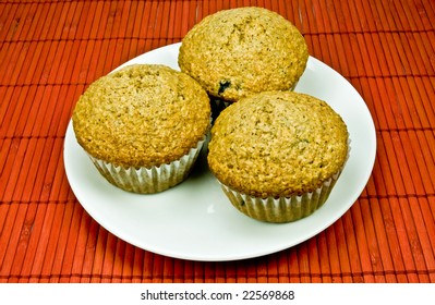 Fresh Baked Blueberry Bran Muffins In Muffin Tin On Rusty Red Placemat