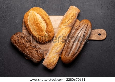 Similar – Image, Stock Photo A freshly baked loaf of bread with a beautiful crust lies on a cooling grid