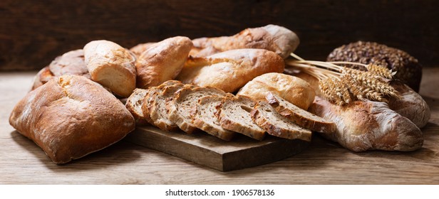 Fresh baked bread and wheat ears on a wooden background - Powered by Shutterstock