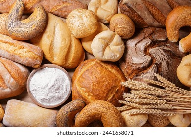 Fresh baked bread and wheat ears as background, top view - Powered by Shutterstock