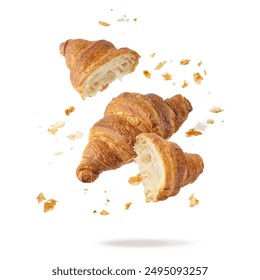 Fresh baked butter breakfast croissants and crumbs falling flying isolated on white background. Whole and broken in half croissants. Pastry shop or bakery card. - Powered by Shutterstock