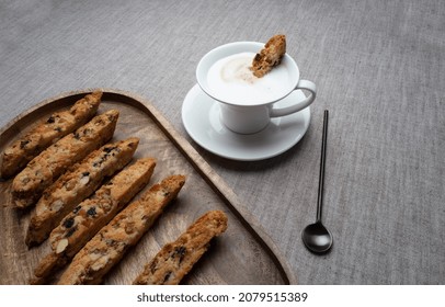 Fresh baked cookies biscotti
on a wooden tray with a cup of cappuccino.