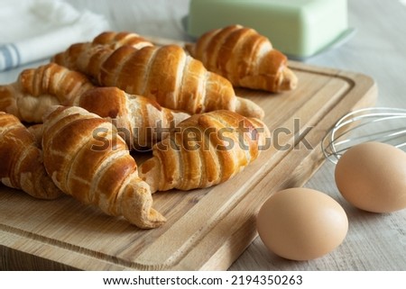 fresh baked croissants on the kitchen board with eggs, circlet