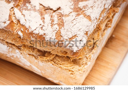 Foto Bild gebackenes Roggenbrot liegt Mehl auf einem Textiltuch.