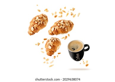 Fresh Baked French Butter Almond Nut Croissants And Black Cup Hot Coffee Flying With Flakes And Crumbs Isolated On White Background. Pastry Shop Or Cafe Card