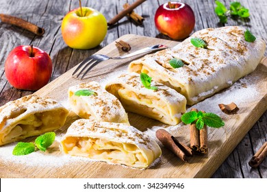 fresh baked homemade apple strudel with powdered sugar and mint leaves.