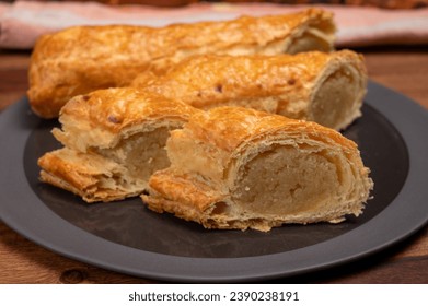 Fresh baked homemade Dutch filled spicy cookies from puff pastry with almonds on black board close up - Powered by Shutterstock