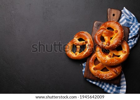 Fresh baked homemade pretzel with sea salt on stone table. Classic beer snack. Top view flat lay with copy space