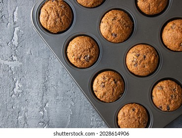 Fresh baked homemade raisin bran muffins in baking dish on dark gray texture background. Close up, copy space, horizontal view from above - Powered by Shutterstock