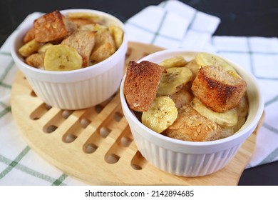 Fresh Baked Mouthwatering Banana Bread Pudding in Ceramic Bowls on Wooden Breadboard
