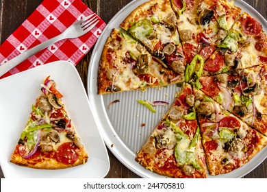 Fresh Baked Slice Of Thin Crust Supreme Pizza Sitting On White Plate With Red Heart Napkin And Fork