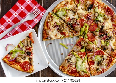 Fresh Baked Slice Of Thin Crust Supreme Pizza Sitting On White Square Plate With Red Heart Napkin And Fork