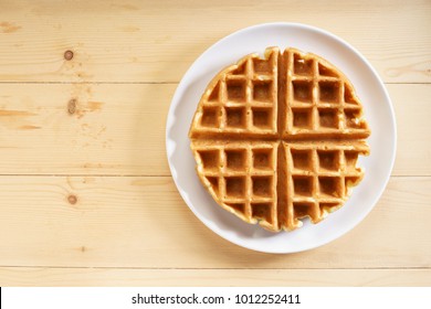 fresh baked waffle in a pattern on wooden background, top view