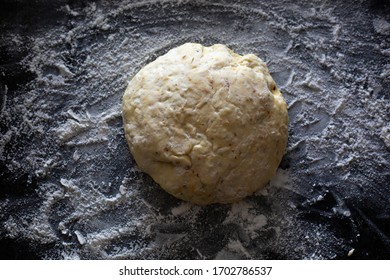 Fresh Ball Of Pizza Dough On A Lightly Floured Dark Countertop. Perfect Recipe For Family Pizza Night For Couples And Kids. Recipe Made From Sourdough Discard