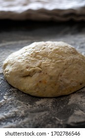 Fresh Ball Of Pizza Dough On A Lightly Floured Dark Countertop. Perfect Recipe For Family Pizza Night For Couples And Kids. Recipe Made From Sourdough Discard