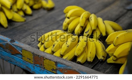Fresh Banana bunches kept on wooden surface in fruit market. Selective focus.