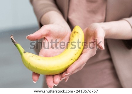 Fresh banana in a female hand isolated on white