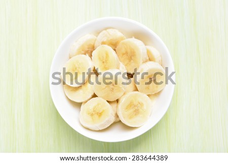 Fresh banana fruits in bowl, top view.