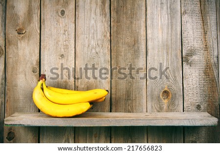 Fresh bananas on wooden shelf.