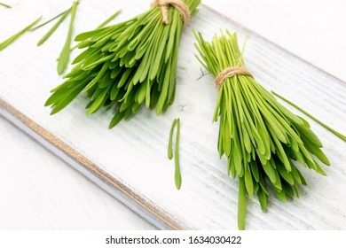 Fresh Barley Grass On A White Wooden Background