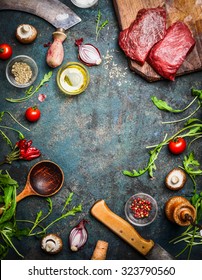 Fresh Beef Steak, Wooden Spoon, Knife And Aromatic Herbs, Spices And Vegetables For Cooking , On Rustic Background, Top View, Frame.