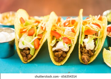 Fresh Beef Tacos In Hard Yellow Corn Taco Shell With Sour Cream And Shredded Cheese.