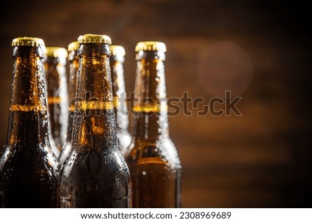 Fresh beer in closed bottles. On rustic background.