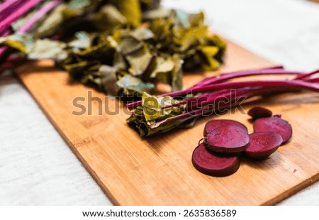 Fresh beetroot on a rustic table cloth and beet cuts on a cutting board. Process of preparing beetroot for cooking. Local food concept.