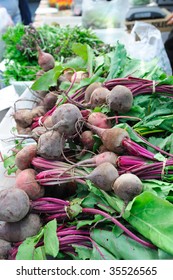 Fresh Beets on a table lined up for sale at a farmers market.