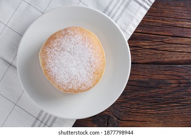 Fresh berliner donut on a plate on wooden table, top view - Powered by Shutterstock