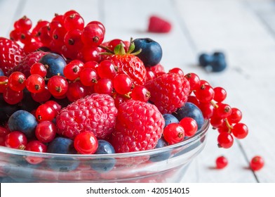 Fresh Berries (raspberry, Red Currant, Blueberry) In Glass Bowl On Wooden Table 