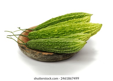 Fresh bitter melon (Momordica charantia), also known as bitter gourd, on a wooden cutting board. Isolated on white background. - Powered by Shutterstock