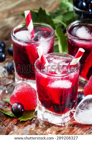 Fresh blackcurrant drink with berries and ice in a heart shape, selective focus