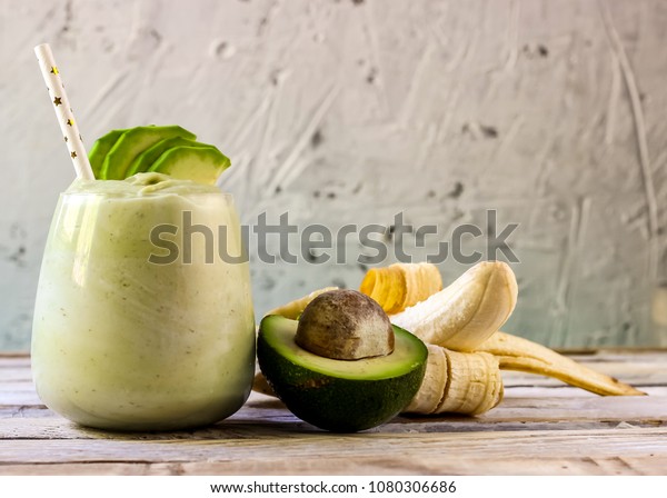 Fresh blended Banana and\
avocado smoothie with yogurt or milk in glasses, healthy eating,\
superfood