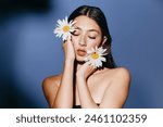 Fresh Blooming Beauty: Young Woman with Flowers in Her Hair, Posing in a Green Field - Closeup Portrait of a Pretty Caucasian Model in Spring.