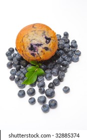 Fresh Blueberries Surround A Single Blueberry Muffin On A Light Background